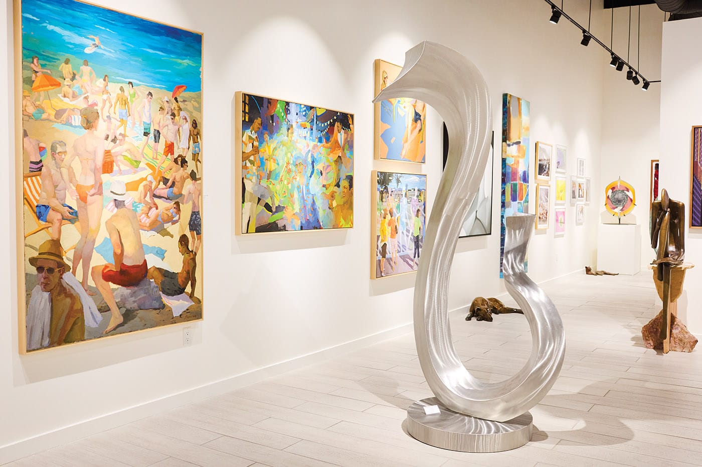 From left: Four paintings by Michael Steirnagle; stainless sculpture by Kevin Robb; tall abstract painting by Anthony Liggins; bronze dog and cat sculptures by Silvia Davis; glass shield sculpture by Davide Salvadore; and bronze girl reading sculpture by John Kennedy. All at Coda Gallery.